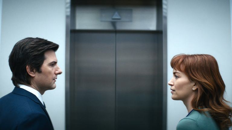 Mark S (Adam Scott) and Helly R (Britt Lower) look at each other outside an elevator in Severance season 1.